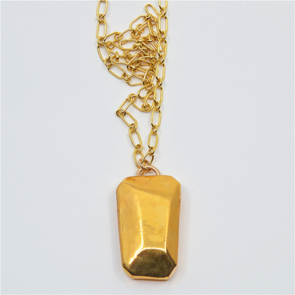 This unique pendant is handcrafted of porcelain, faceted and painted by hand with 22 karat gold glaze. The pendant is attached to a 14 karat gold-filled ring and gorgeous chain.