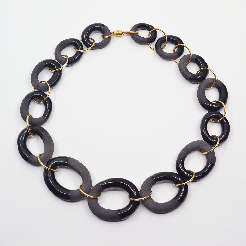 Unique choker chain made of handcrafted black porcelain chain links. The porcelain links are partially glazed with shiny black glaze, partially left unglazed. With 14 karat gold-filled rings and magnetic clasp.
