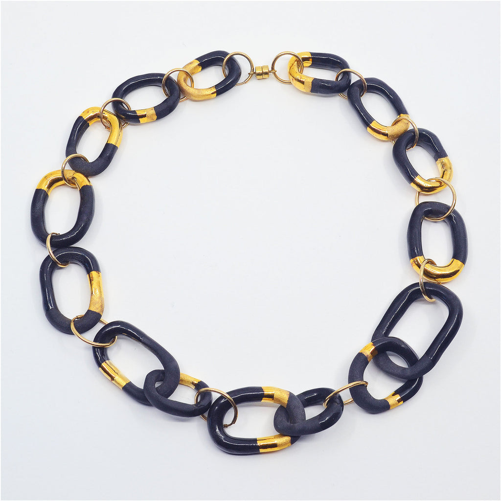 Unique porcelain chain link choker necklace, handcrafted of black porcelain, the chain links are glazed with shiny black, and matte and glossy gold luster, the links are partially left unglazed. With 14 karat gold-filled rings and magnetic clasp.