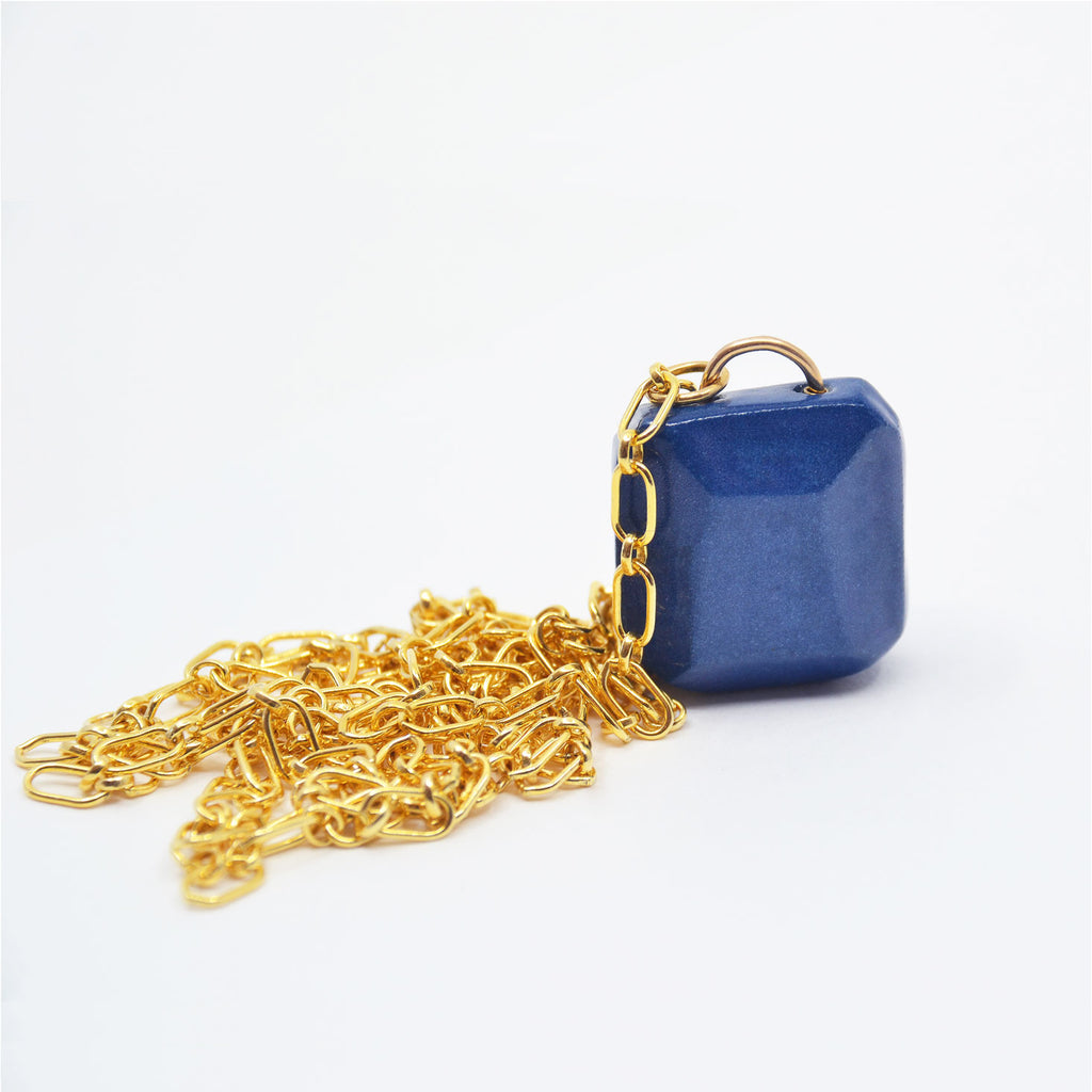 This beautiful pendant necklace is hand made. The pendant is crafted of porcelain and faceted by hand, glazed in navy blue color. The pendant is attached to a gorgeous 14 karat gold-filled long chain.