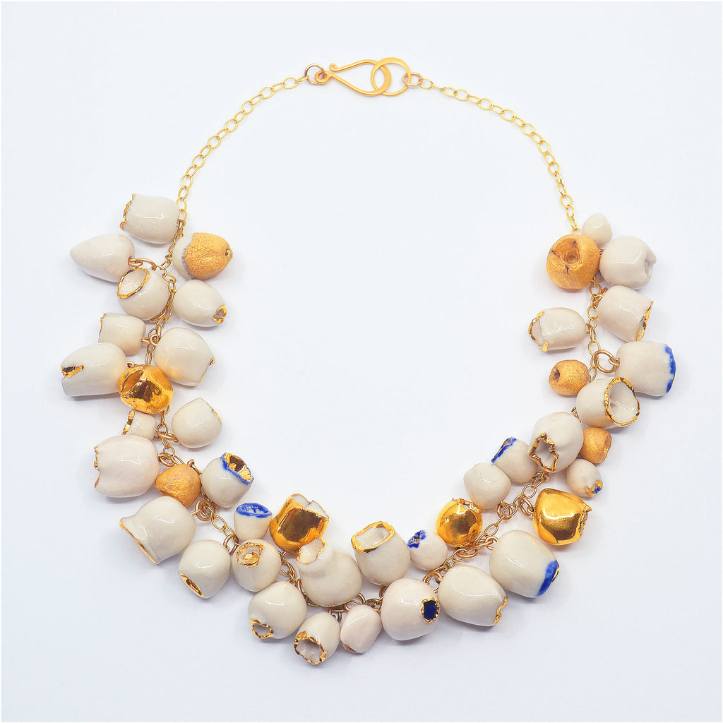 Unique porcelain flower choker necklace, handmade flower beads in white, blue and gold on 14 karat gold-filled chain with hook clasp. 