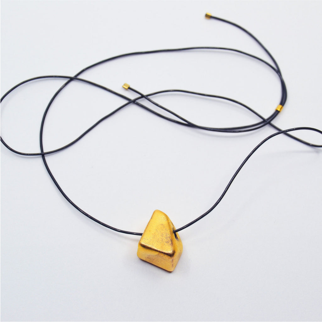 This adorable necklace is made by hand. The bead is crafted of porcelain and glazed with 22 karat gold. The bead is strung on a black and high quality latex-free jewelry cord, and is adjustable in length.