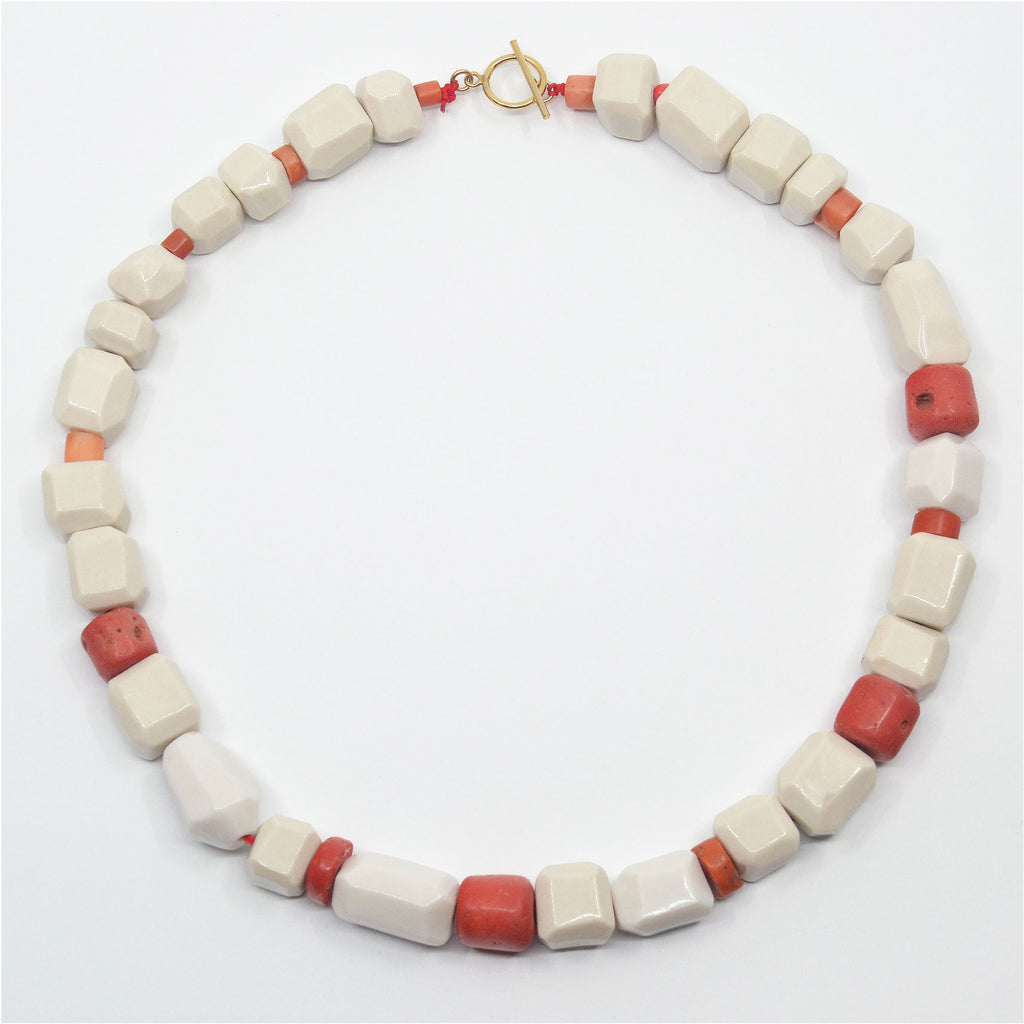 Unique Porcelain choker necklace, made of hand-faceted white porcelain beads and vintage orange-red corals. The clasp is a 14 karat gold-filled toggle clasp.
